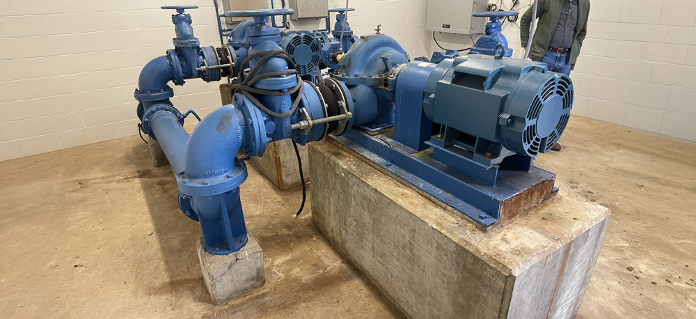 Existing booster pump station equipment with a split-case centrifugal pump, electric motor, and blue gate valves, part of Columbia Power & Water Systems' Distribution System Improvement Program.